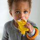 Photo of a baby chewing on banana-shaped teething toy.