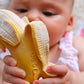 Photo of a baby holding banana-shaped teething toy.