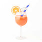 Aperitif in a stemmed glass with an orange slice and blue straw on a white background