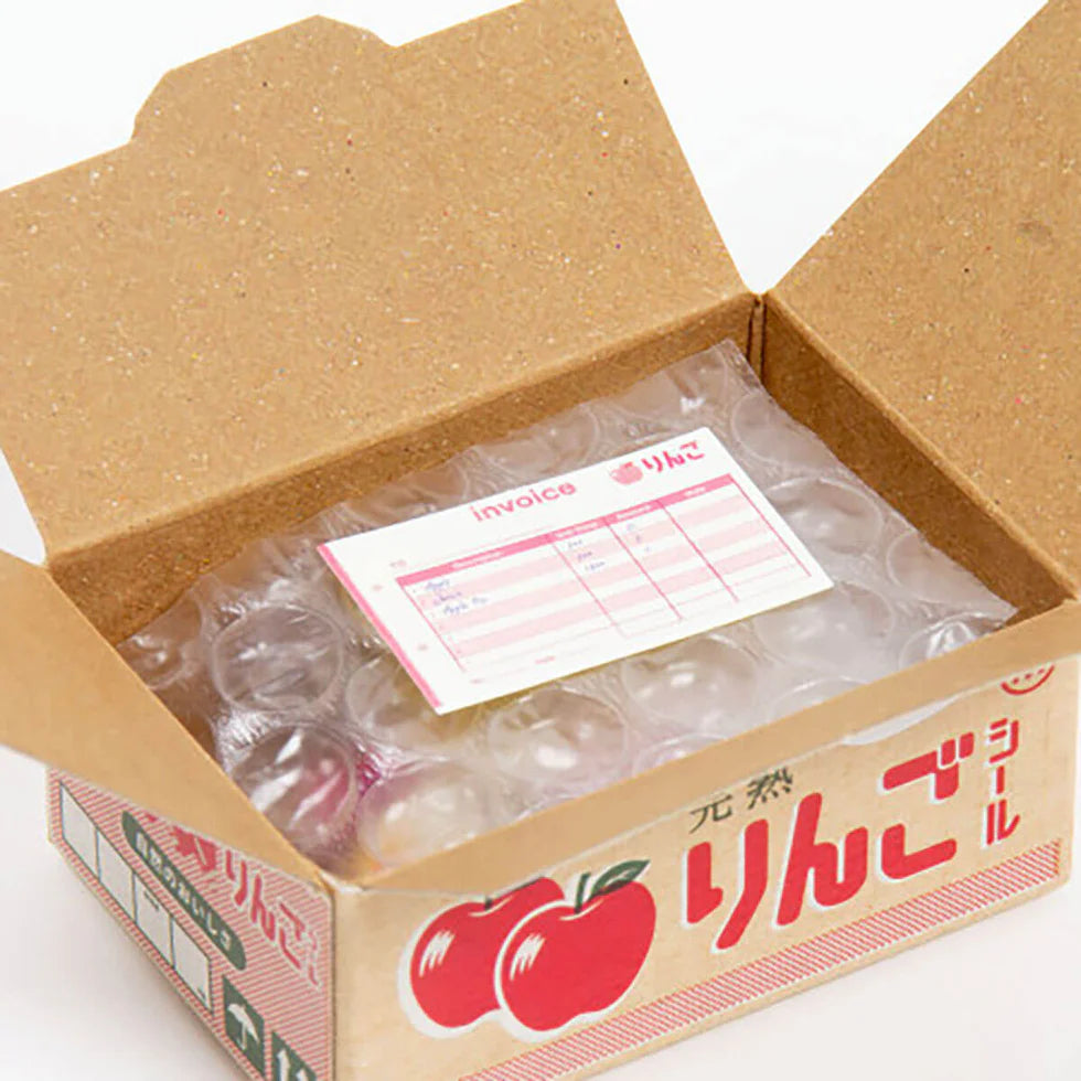 Cardboard box with bubble wrap and an invoice inside, featuring Japanese text and apple graphics.