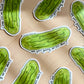Green pickle-shaped stickers with text "are you going to eat that?" on a beige background