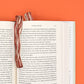 Two slices of bacon on an open book with an orange background