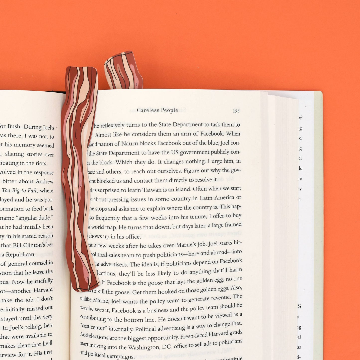 Two slices of bacon on an open book with an orange background