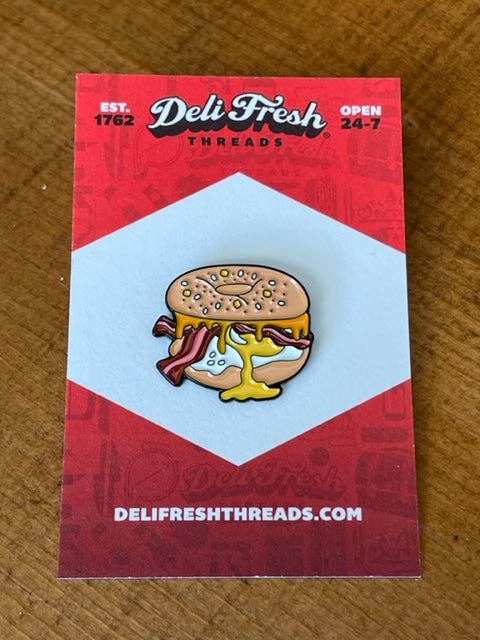 Bagel sandwich lapel pin on a card backing.