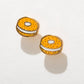 Pair of earrings shaped like bagels with orange and white design on a light gray background