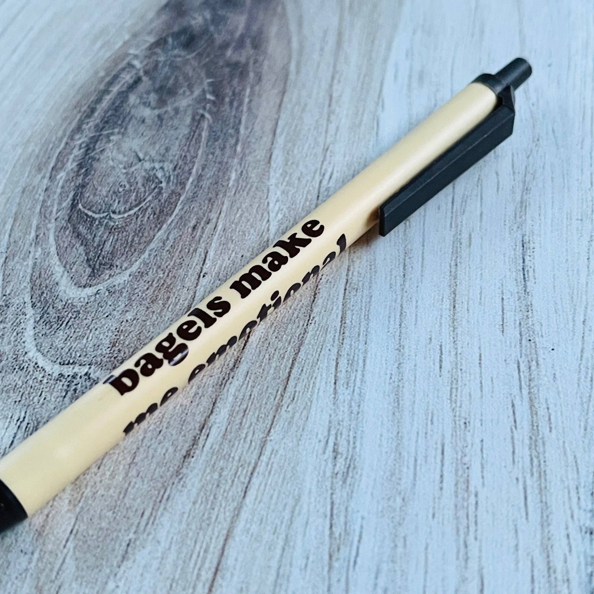 Bic Clic-Pen with text that says "bagels make me emotional" on a wooden surface