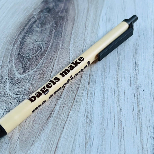Bic Clic-Pen with text that says "bagels make me emotional" on a wooden surface