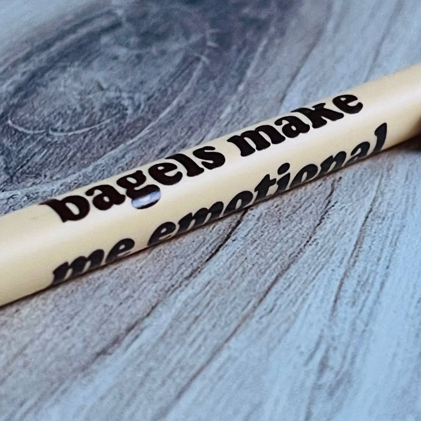 Pen with text 'bagels make me emotional' on a textured surface