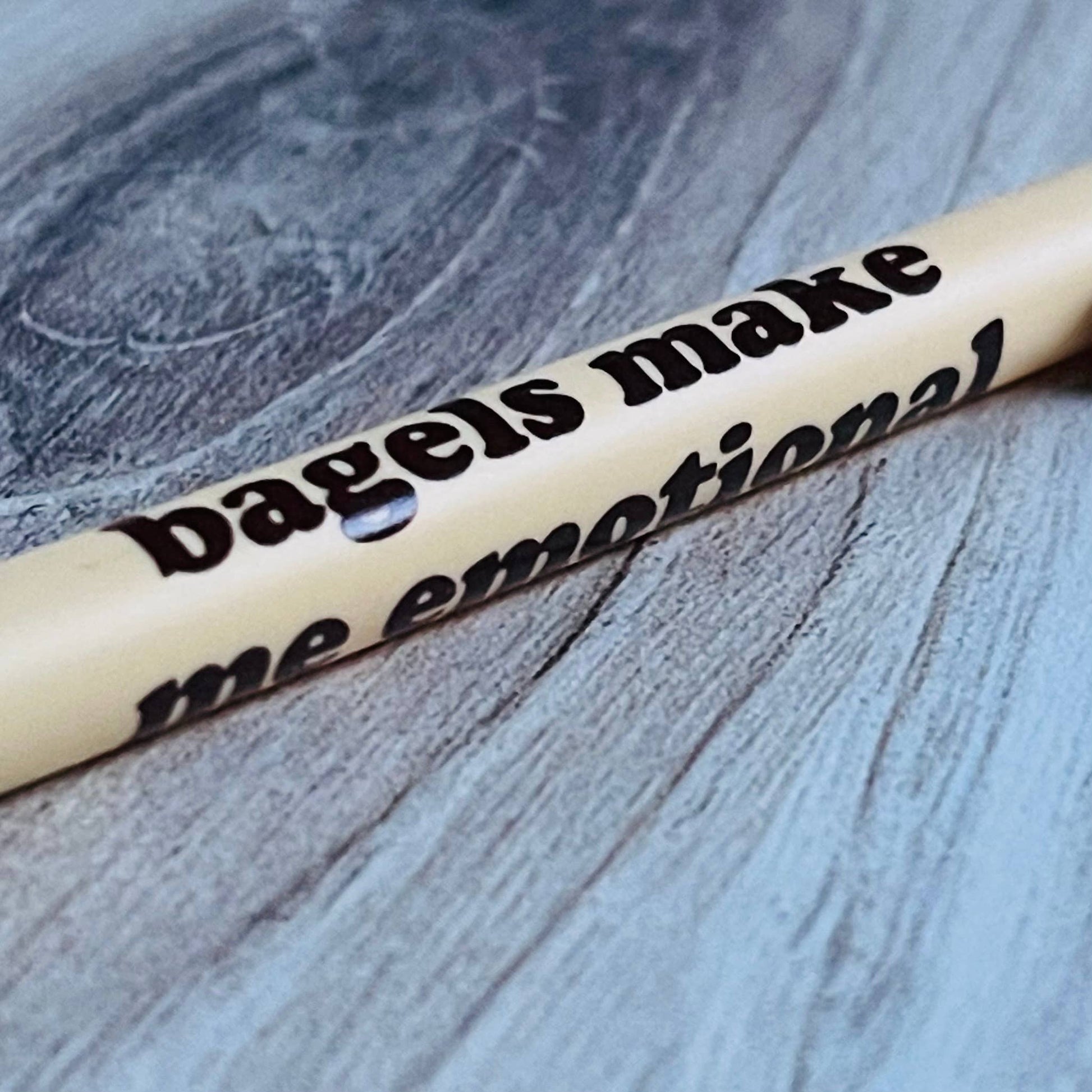 Pen with text 'bagels make me emotional' on a textured surface