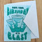 Birthday card with a Baja Blast soda graphic and text on a wooden surface with white envelope 