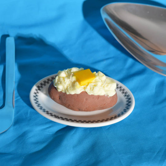 candle that looks like a baked potato with a pad of butter on top 