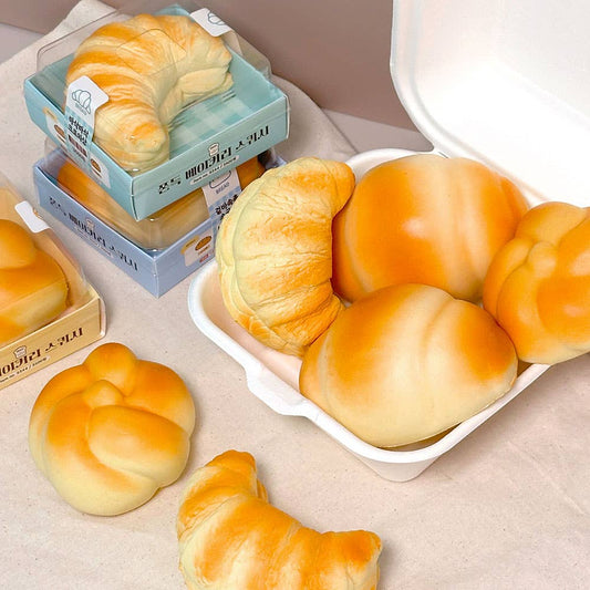 Assorted bread stress balls including croissants and buns on a neutral background
