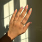 Hand with colorful nail designs using the candy heart nail stickers against a window with sunlight casting shadows.
