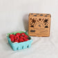 Carton of raspberry candles with a cardboard box on a light background