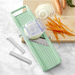 Benriner green mandoline with attachments and finger guard. Picture displays a white onion being sliced and a carrot already julienned. 