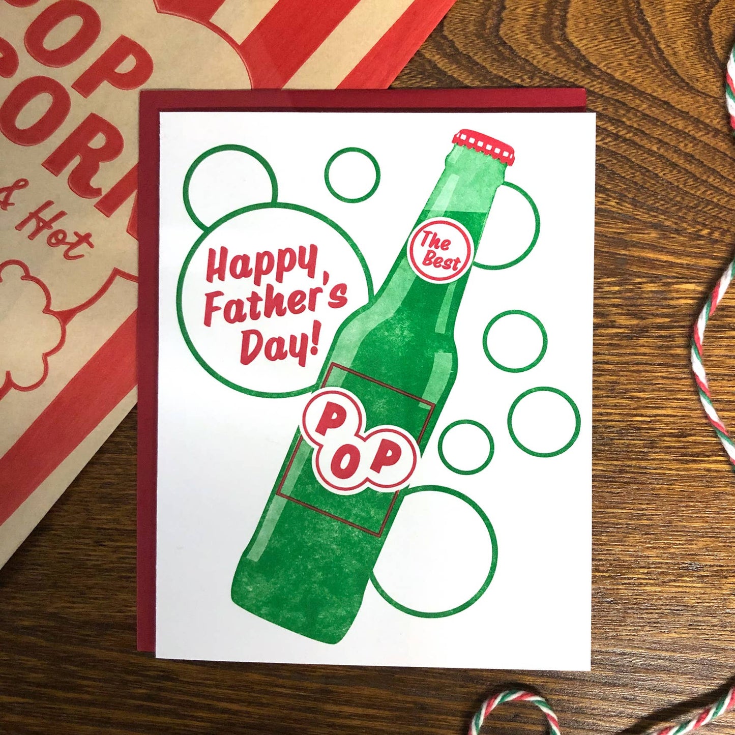 Father's Day card with a green soda pop bottle design on a wooden surface