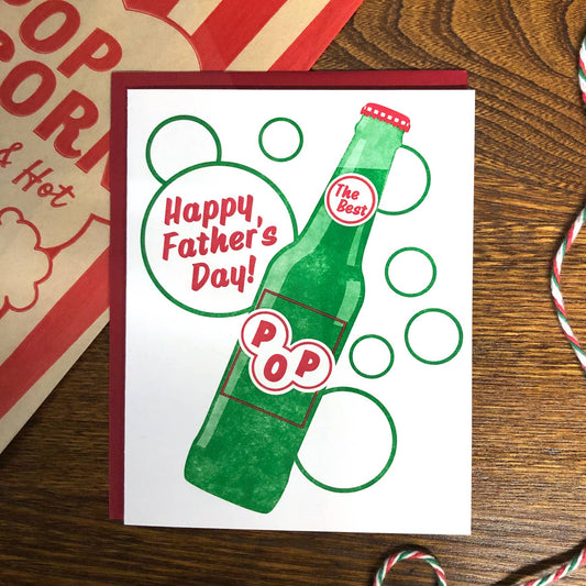 Father's Day card with a green soda pop bottle design on a wooden surface