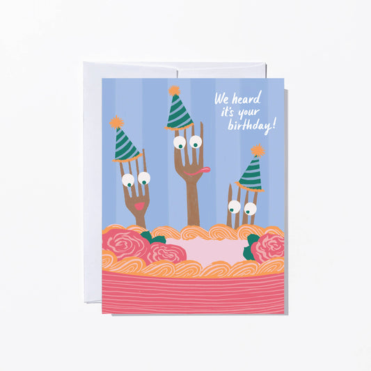 Birthday card with cartoon utensils in a cake, text 'We heard it's your birthday!' on a blue background.