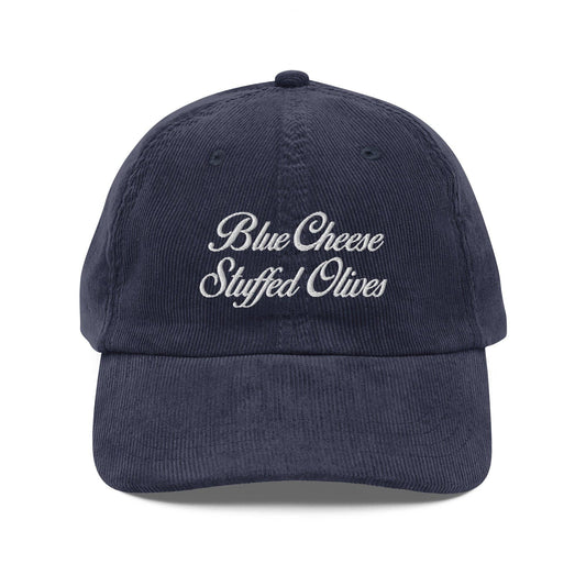 Blue corduroy cap with 'Blue Cheese Stuffed Olives' text on a white background
