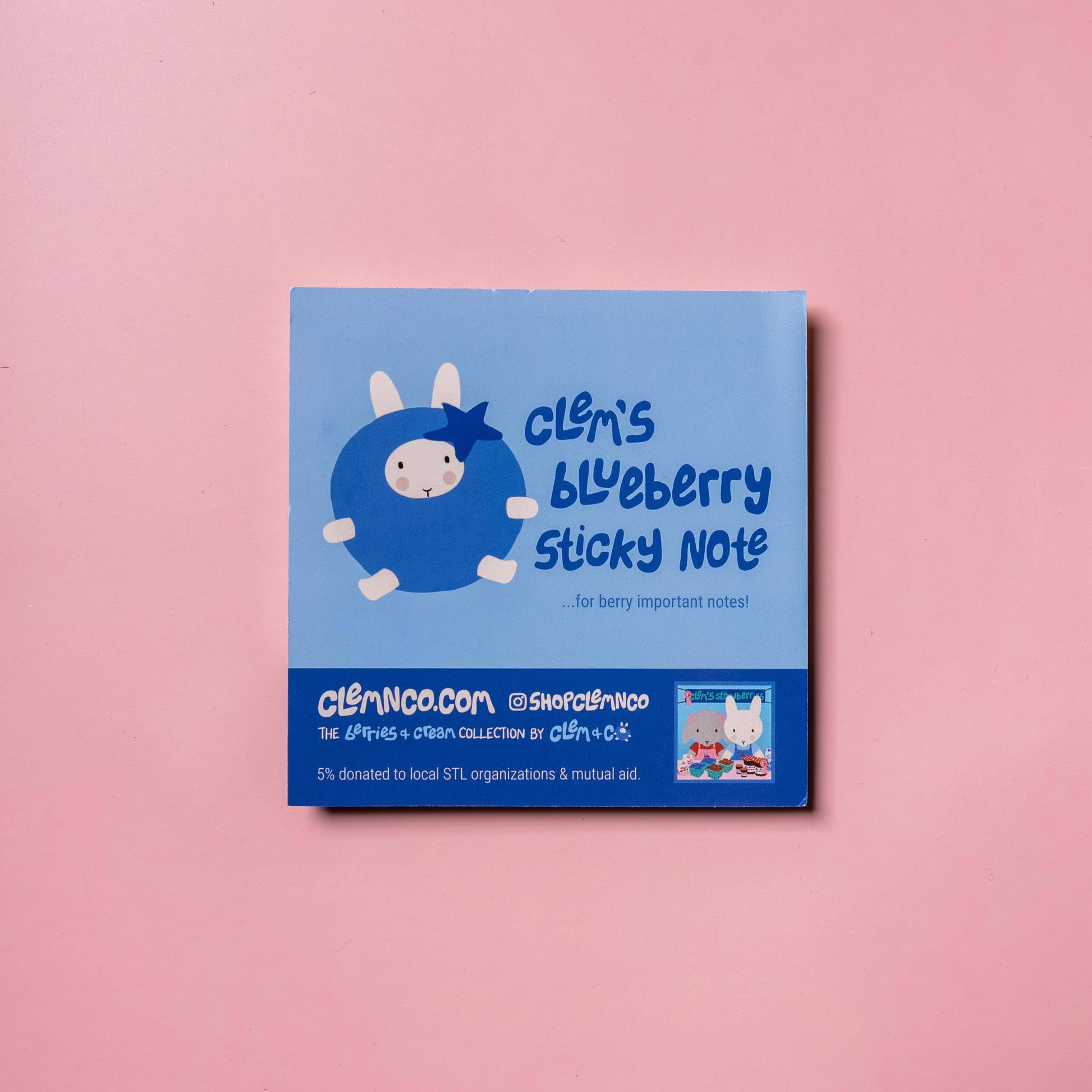 Blue sticky note pad with cartoon character on a pink background