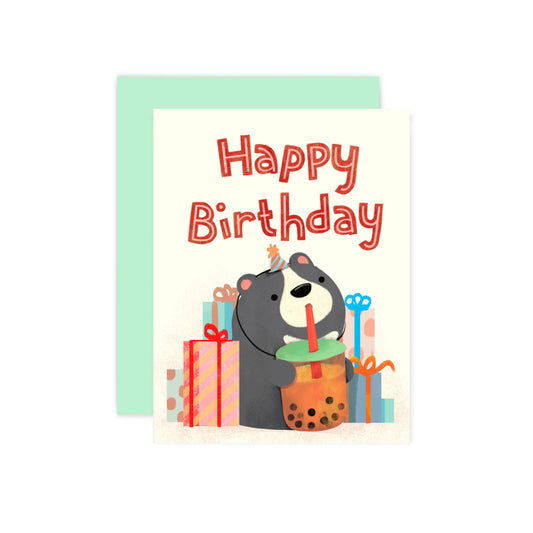 Birthday card with a bear holding a bubble tea and sitting in front of gift boxes on a white background