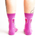 Pink socks with colorful boba bubble tea drink illustrations and heart patterns on a white background