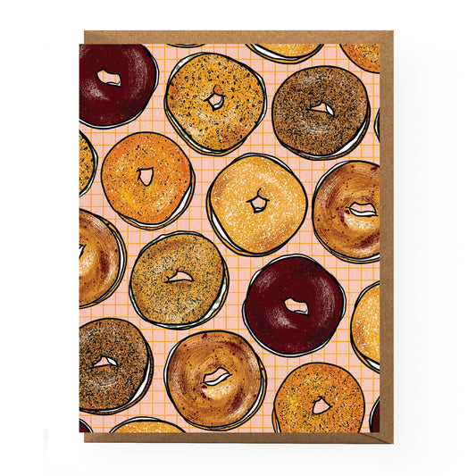 A boxed set of 6 cards -- design features a pink background with a small, orange grid pattern and various types of bagels with cream cheese all over