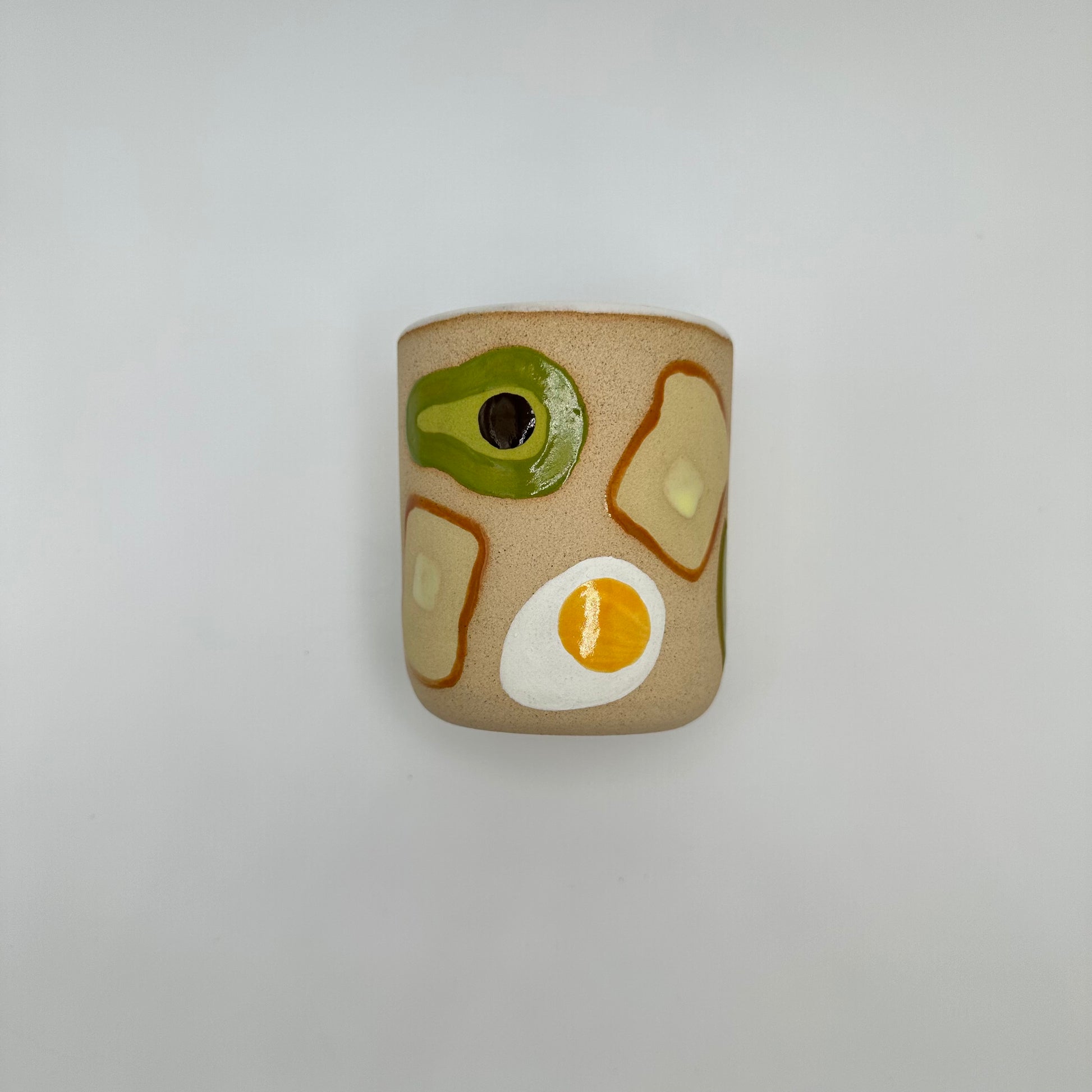 Ceramic Tumlber with hard boiled eggs, avocados and toast with pads of butter hand painted on.