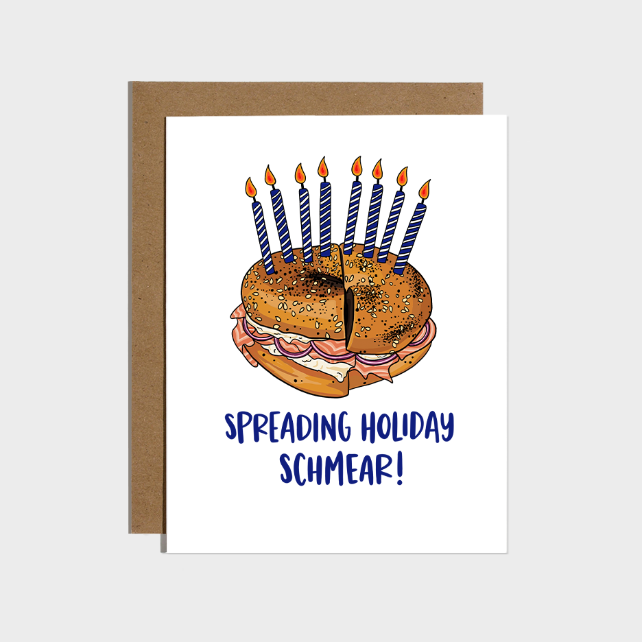 Hanukkah card that has an illustration of an everything bagel with lox, schmear and red onions with 8 blue and white candles on it. Text reads "Spreading holiday schmear1" 