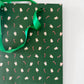 Green holiday gift bag with boba and candy canes all over 