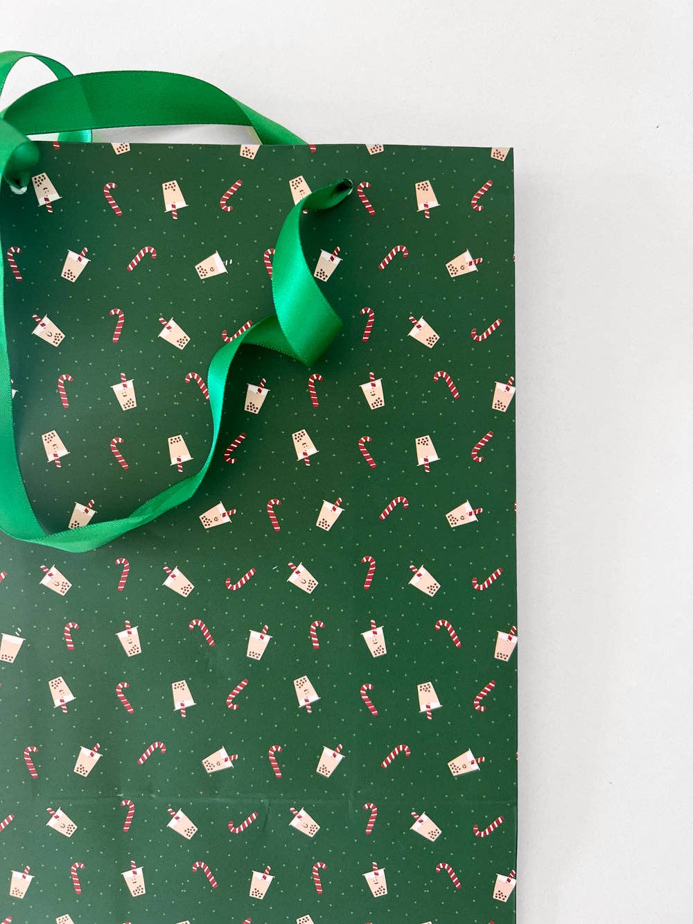 Green holiday gift bag with boba and candy canes all over 
