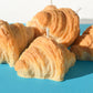 Pile of six croissant candles on a plate.