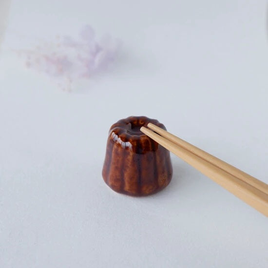 Canele chopstick holder with chopsticks on it.