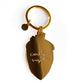 Backside of strawberry keychain. All gold with "Carolyn Suzuki" inscription. 