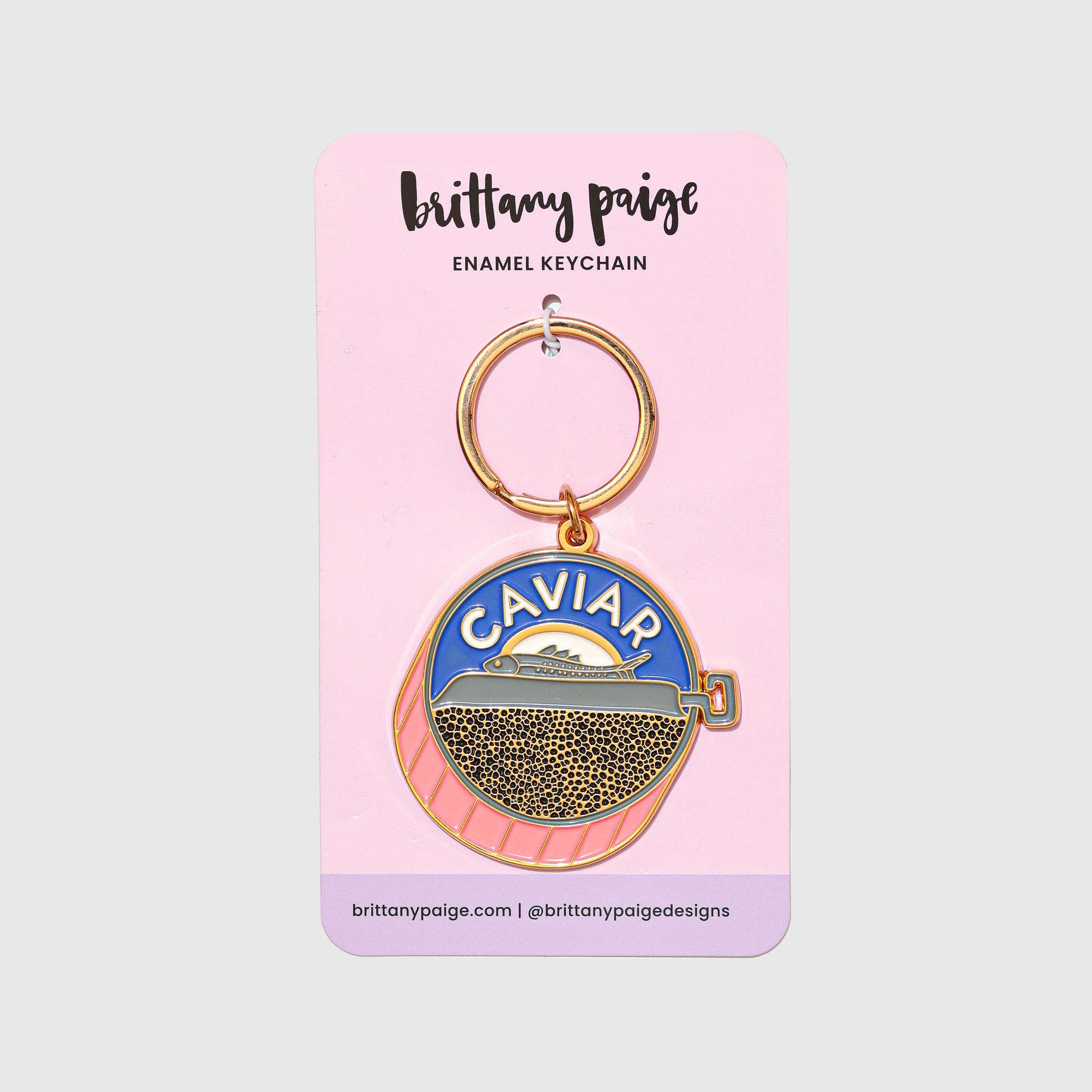 Enamel keychain with 'Caviar' design on a pink card with 'brittany paige' branding.