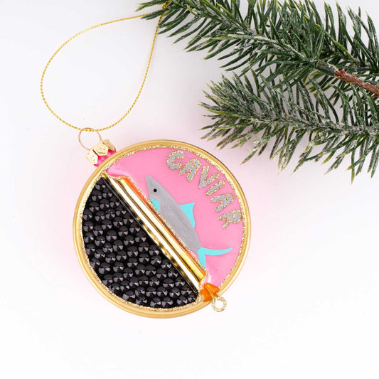 Decorative caviar tin ornament with fish design on a branch