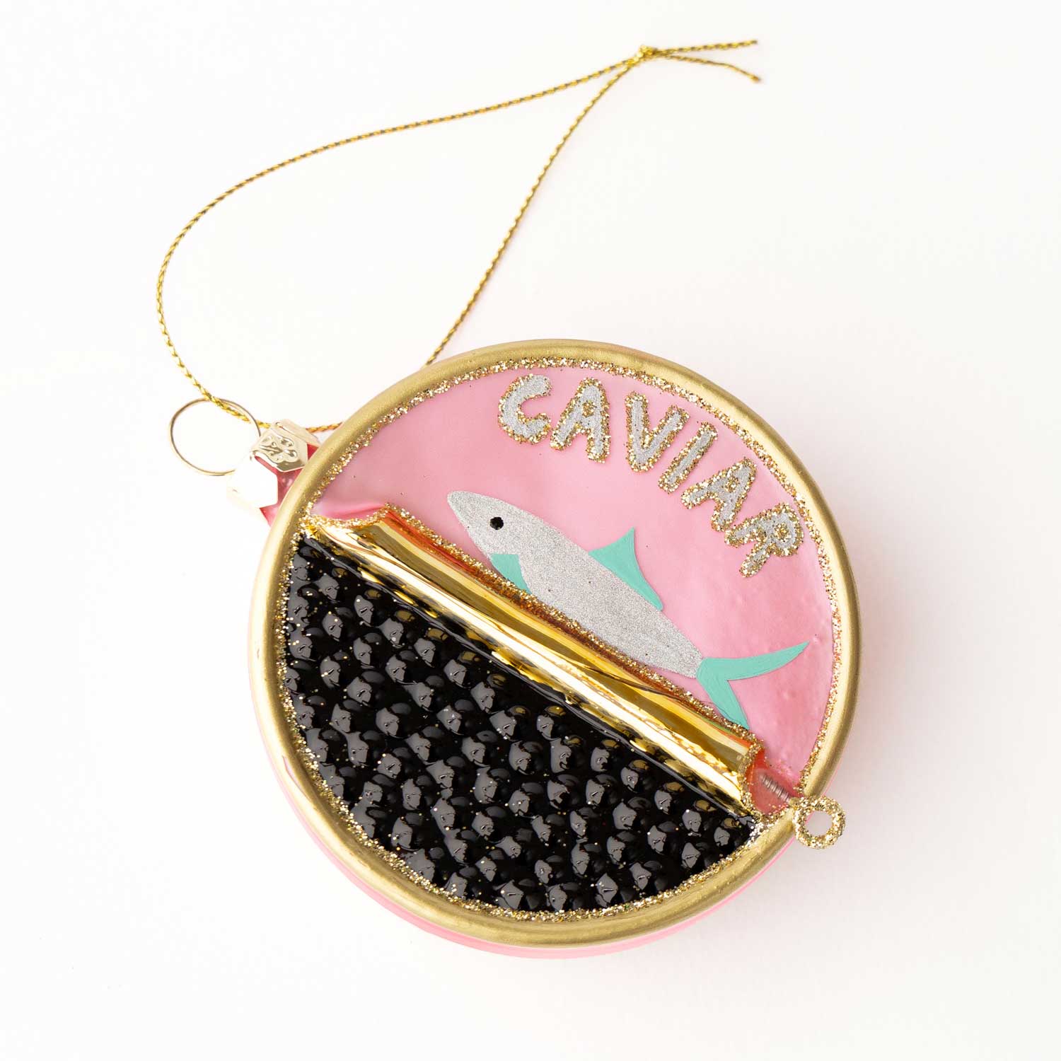 Decorative caviar tin ornament with fish design and 'CAVIAR' text on a pink background