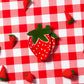 Strawberry-shaped trinket dish on a red and white checkered tablecloth