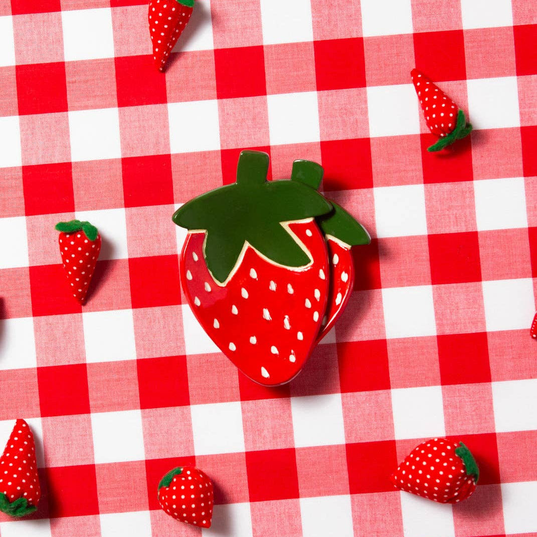 Strawberry-shaped trinket dish on a red and white checkered tablecloth