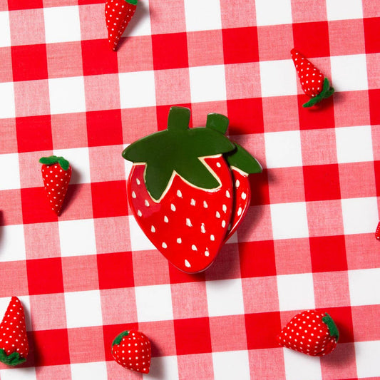 Strawberry-shaped trinket dish on a red and white checkered tablecloth