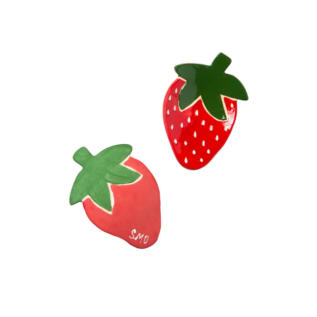 Two strawberry trinket dishes with green leaves on a white background