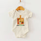 Baby onesie with charcuterie design on a hanger against a white background