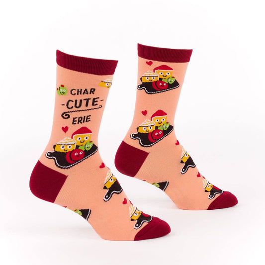 Pair of pink and burgundy socks with cartoon illustration of a charcuterie board design and text (char-CUTE-erie) on a white background