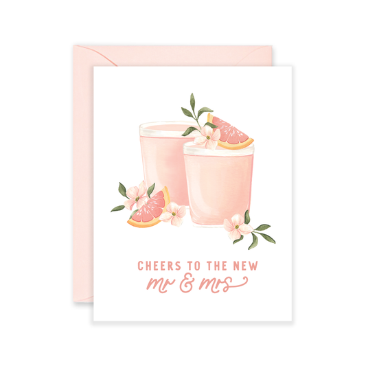 Greeting card with pink cocktails and grapefruit slices on a white background. Text reads "Cheers to the new Mr. & Mrs."