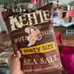 Kettle Chips party size sea salt bag held in a casual setting with the nude cheez it sticker on it 