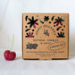Box of Happy Organics birthday candles with a cherry on a white background