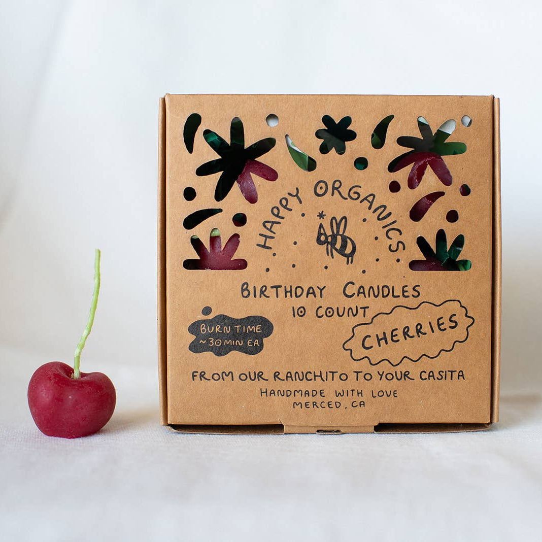 Box of Happy Organics birthday candles with a cherry on a white background