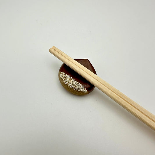 Chestnut chopstick holders with chopsticks.