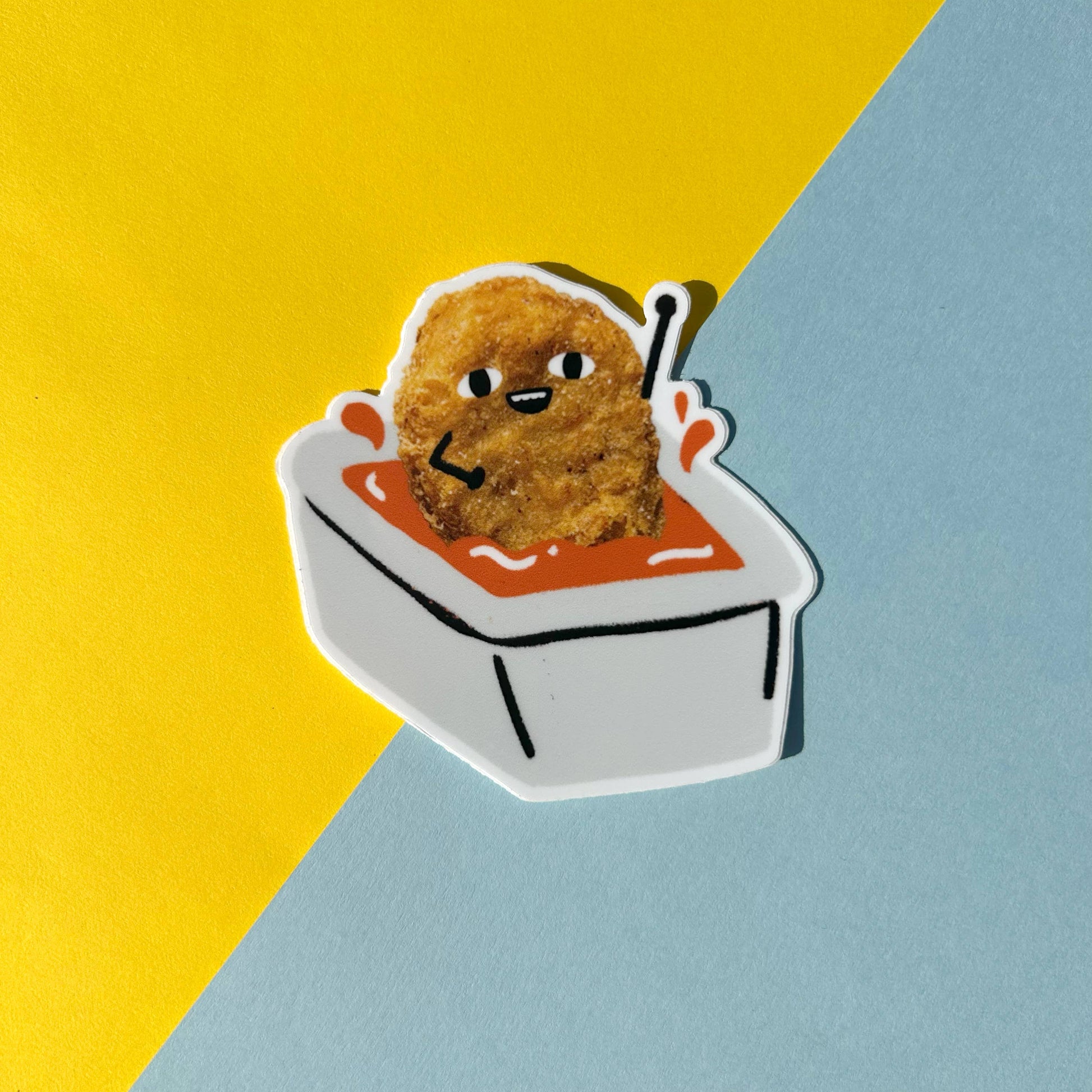 Illustration of a fried chicken nugget dipped in sauce on a yellow and blue background