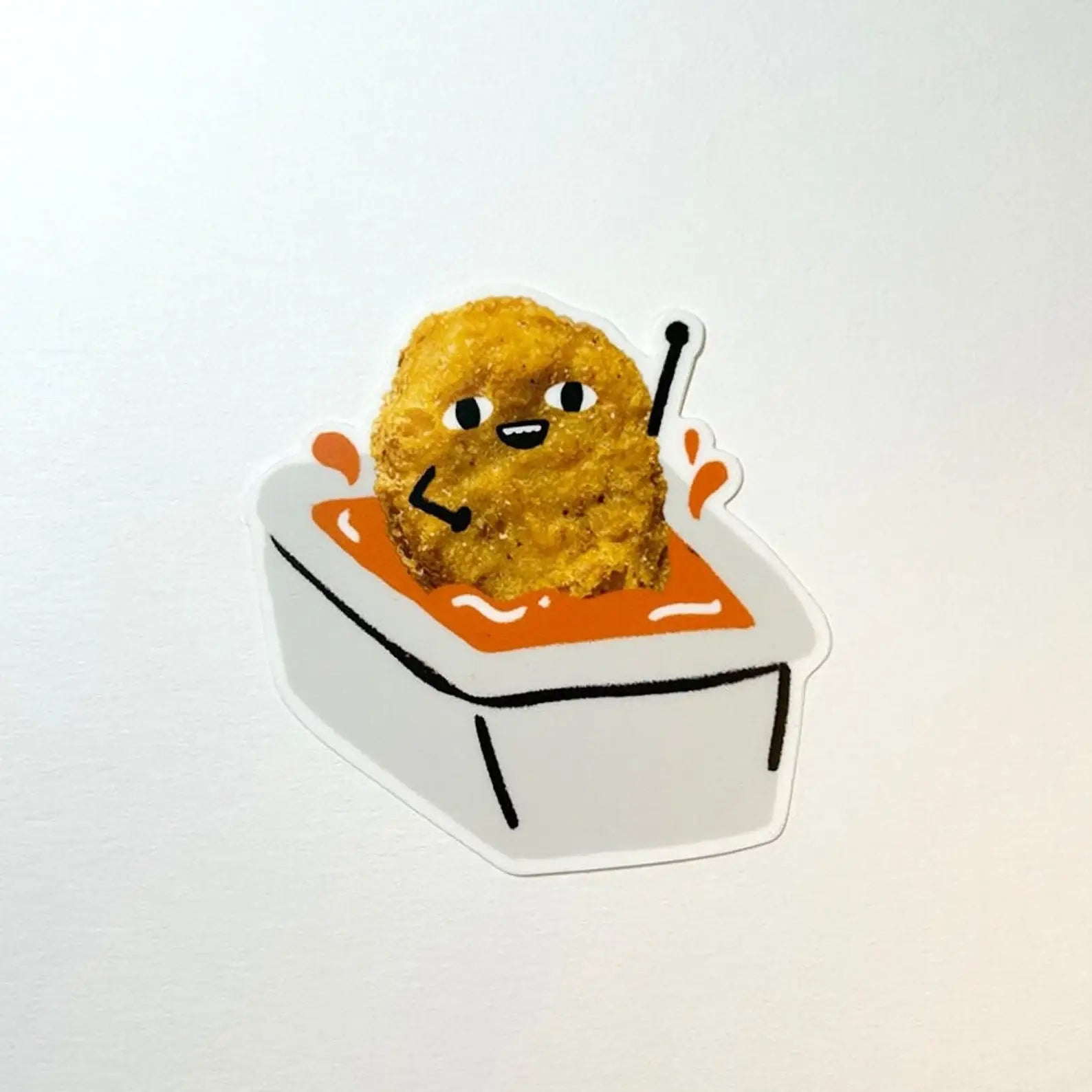 Sticker of a chicken nugget in a sauce container with cartoon face on a white background